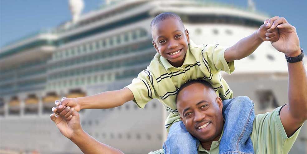 Father and son smiling in front of cruise ship